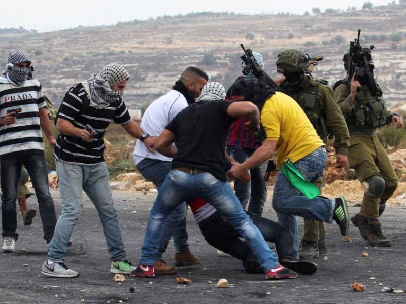 Members of Israeli security forces disguised as Palestinians fire bullets into a demonstration outside Ramallah on October 7, 2015.  (AFP/Abbas Momani)