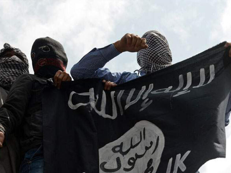 Daesh militants hold their flag on display. (AFP/File)