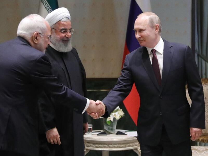 Russian President Vladimir Putin (R) shakes hands with Iranian Foreign Minister Mohammad Javad Zarif during a meeting with Iranian President Hassan Rouhani in Ankara on April 04, 2018. 
(Mikhail KLIMENTYEV /Sputnik/AFP)
