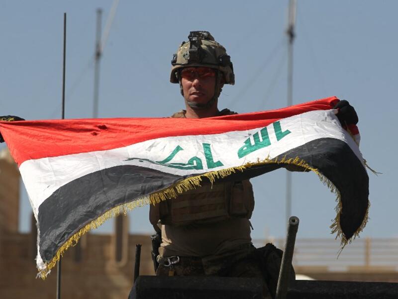 An Iraqi soldier celebrates victory over Daesh in Mosul last month (AFP)