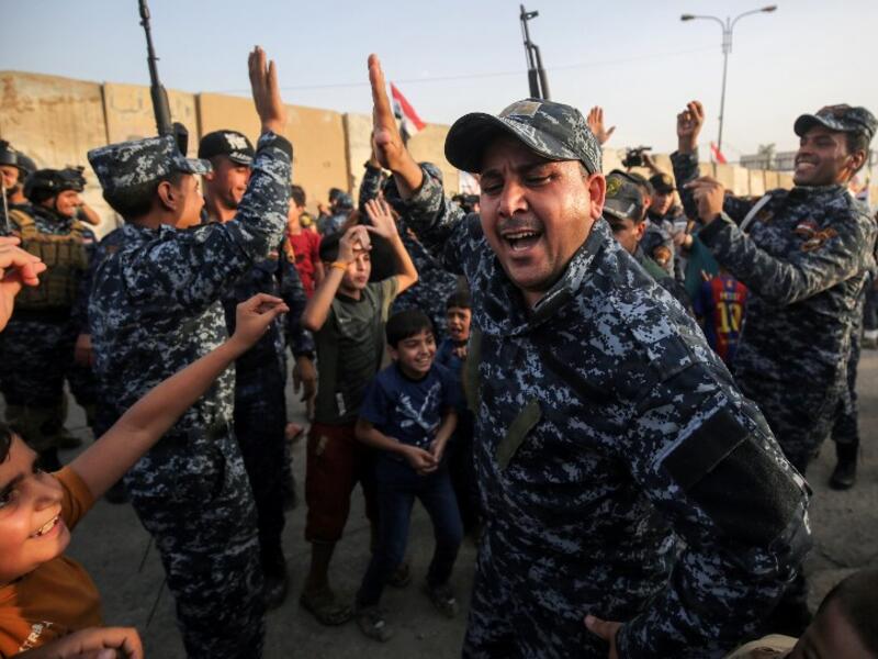 Members of the Iraqi federal police dance with children during a celebration in the Old City of Mosul, where the gruelling battle to retake Iraq's second city from Islamic State (IS) group fighters is now nearing its end, on July 2, 2017. (AHMAD AL-RUBAYE / AFP)