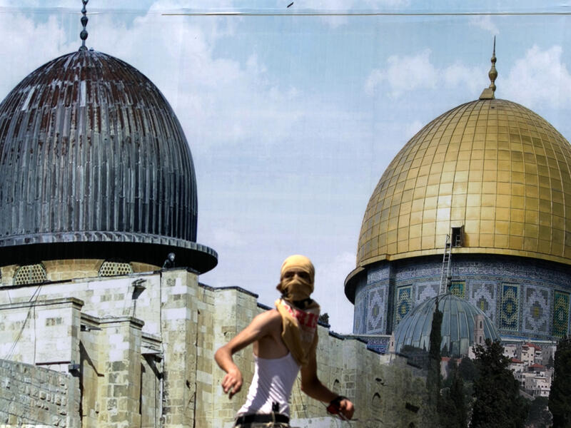 A Palestinian protester stands in front of a mural covered in an image of the Dome of the Rock during clashes between demonstrators and Israeli security forces at the Huwara checkpoint, south of Nablus. (AFP) 