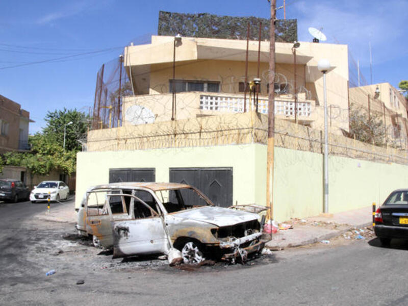 A picture taken on outside the Russian embassy in Tripoli shows a car that was destroyed during an attack. Russia has evacuated all embassy staff from Libya. (Image credit: AFP)