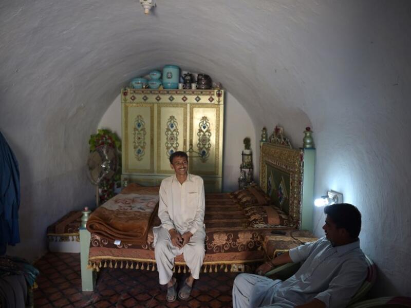 Pakistani villager Ameer Ullah Khan (L) chats with a friend in his cave room in Nikko village.
AAMIR QURESHI / AFP