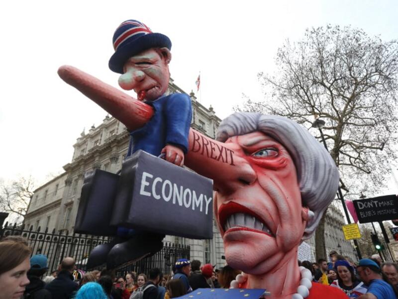A puppet head of Britain's Prime Minister Theresa May spearing a representation of the British economy is positioned on Whitehall outside Downing Street after a march and rally organised by the pro-European People's Vote campaign for a second EU referendum in central London on March 23, 2019. 
Isabel INFANTES / AFP