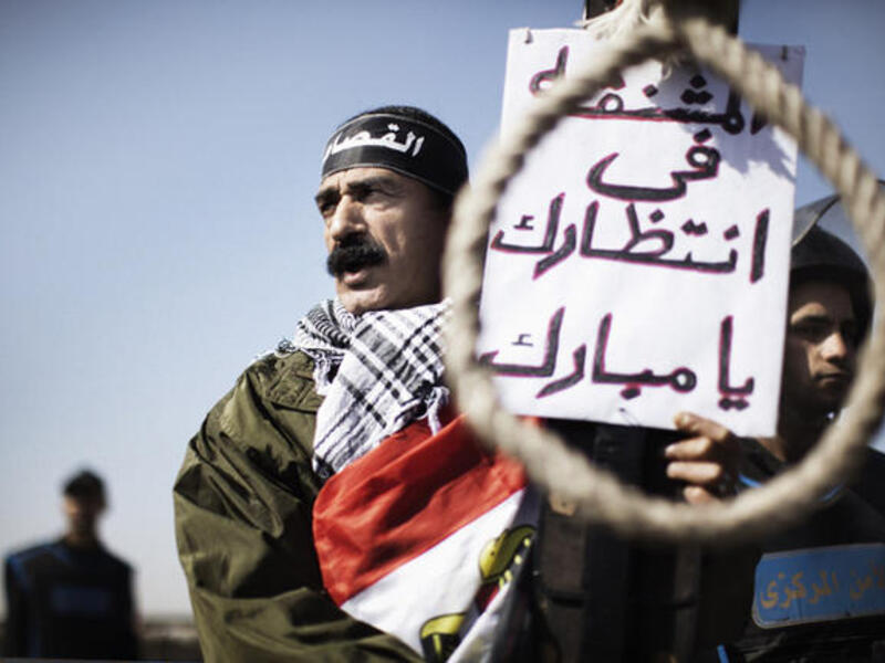 Protestors at Mubarak's sentencing in 2012. The sign reads, "this rope is waiting for you Mubarak." (AFP/File)