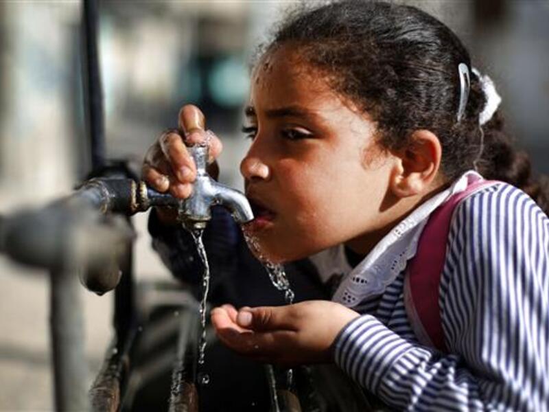 A file photo of a Palestinian child drinking water from a working faucet in Gaza Strip amid a severe water shortage in the besieged territory. (AFP/File)