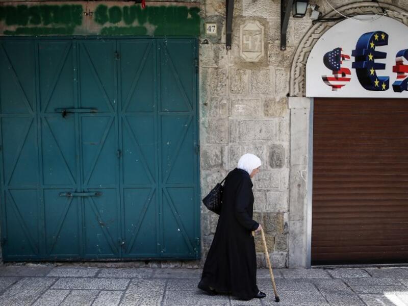 An elderly woman walks past closed shops in the Old City of Jerusalem on April 27, 2017, during a trade strike in support of Palestinian prisoners on hunger strike in Israeli jails. (AFP/Ahmad Gharabli)