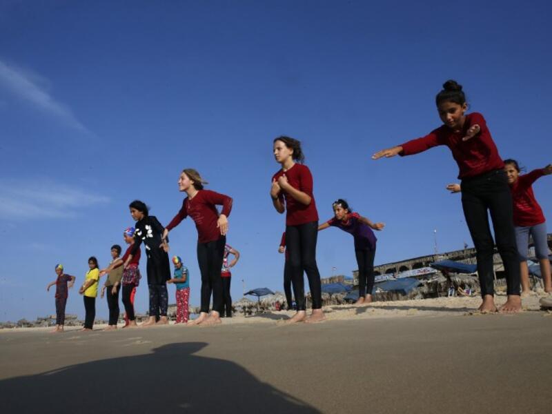 Young Palestinian members of a swimming club, participate in a group excercise on the beach during a training session in Beit Lahia in the northern Gaza Strip. (SAID KHATIB / AFP)