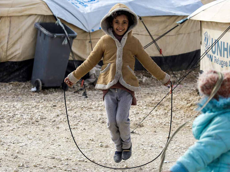 A displaced Syrian child fleeing from Deir Ezzor city besieged by Daesh plays with a skipping rope. As a result of the Syrian crisis, some 2.5 million are living as refugee children in neighbouring countries. These children have lost their homes, schools and communities but do not give up on finding happiness in the small things that remain.