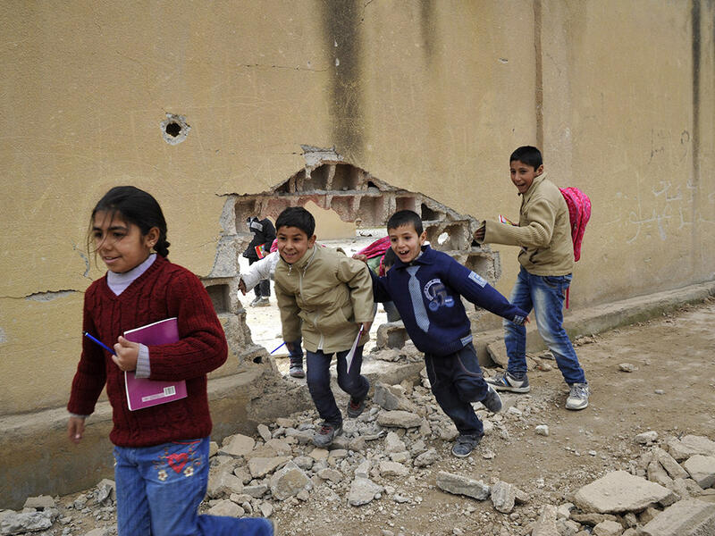 Children run through a huge hole in a wall at the school in Kobani. The Kurdish People’s Protection Units (YPG) reopened the first primary school in 2015, following the defeat of Daesh.