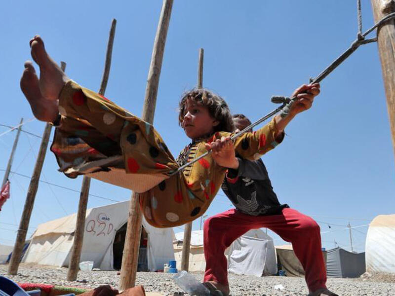 Displaced Iraqi children play on a makeshift swing at al-Khazir camp for the internally displaced, located between Irbil and Mosul. Fighting in Mosul, controlled by Daesh since 2014, has displaced as much as 255,000 people since last October.