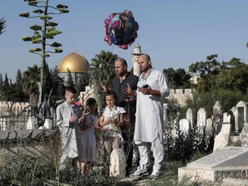 A Palestinian Family at a cemetery in Jerusalem’s old city during Eid. For many Palestinians, visiting the holy city and family members during Ramadan remains difficult. Although Israel issues special Ramadan permits for Palestinians to cross the 1967 border, access remains restricted and after an attack on June 17th, Israel revoked the permits.