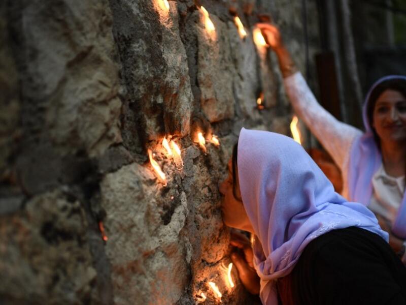 Yazidis kiss the Lalish temple, the place where it is believed that the Peackock Angel, God's representative on earth, descended to bless the earth with fertility and renewal.