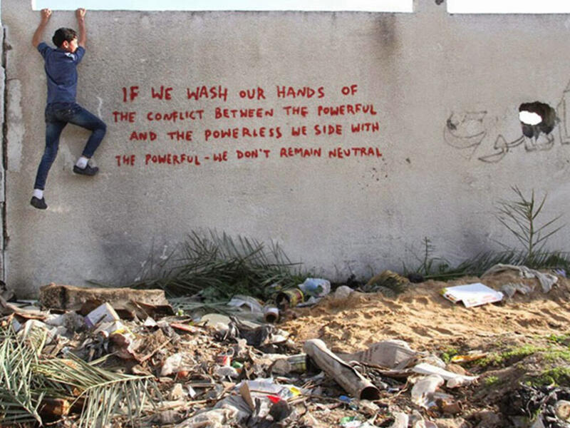 “If we wash our hands of the conflict between the powerful and the powerless we side with the powerful - we don’t remain neutral.” Banksy’s art is simultaneously whimsical and politically charged. His text is becoming more pointed.