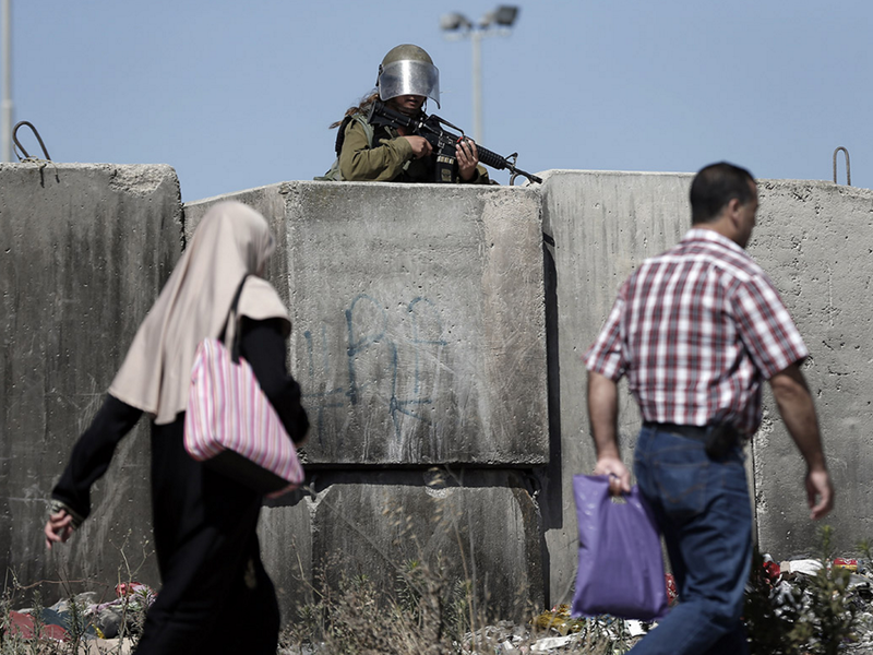 An Israeli soldier stands guard at Qalandiya checkpoint, where the two Palestinian siblings, Maram Abu Ismayil, 23, and Ibrahim Salah Tahah, 16, were shot dead Wednesday. (photo: Thomas Coex/AFP)