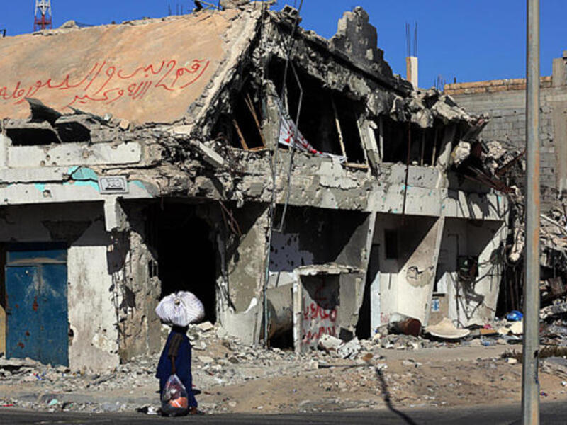 A civilian walks past a destroyed building in Sirte, Libya. (AFP/File)