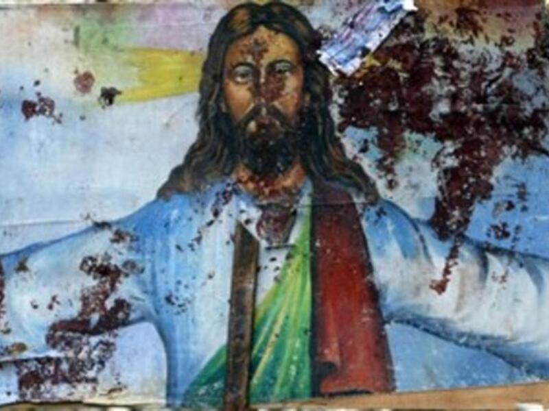 A picture shows a blood-stained image of Jesus Christ outside the Al-Qiddissine church which had been the target of an overnight car bomb attack.