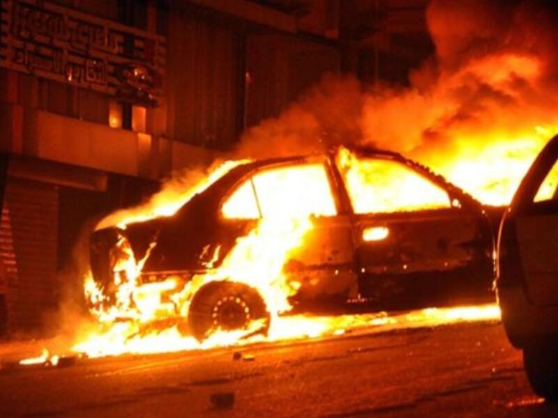 A vehicle burns following a car bomb attack outside the Al-Qiddissine (The Saints) church.