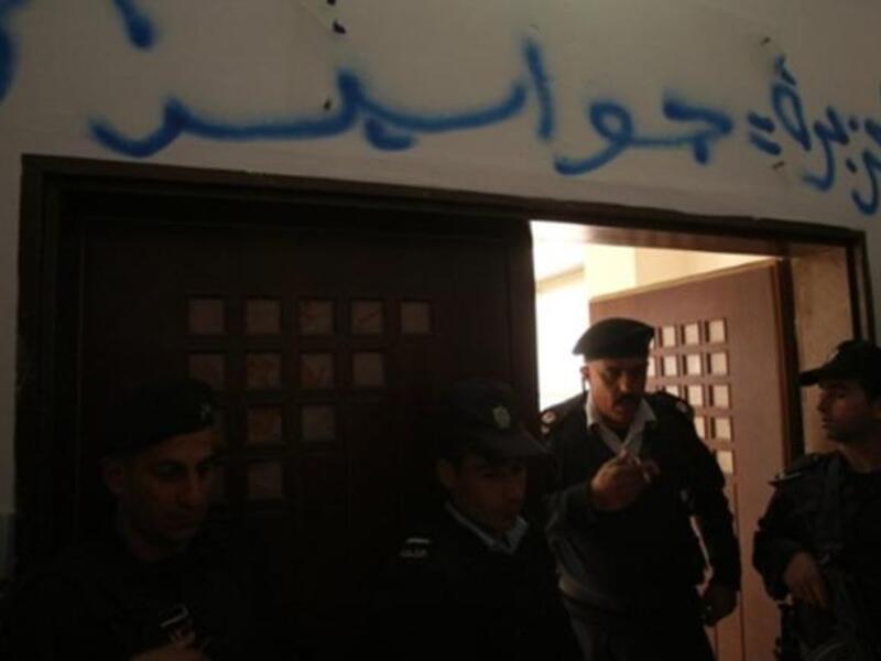 Palestinian security forces stand guard at the entrance of the Al-Jazeera offices in the West Bank city of Ramallah after some protesters stormed into the building and sprayed Arabic graffiti equating the pan-Arab news channel's staff to (Israeli) "spies".