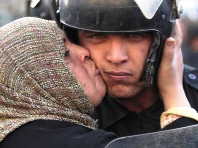امرأة مصرية تقبل جنديا من الأمن المركزي 