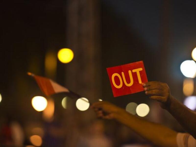 An Egyptian man holds up a red card against the country's Islamist President in front of the presidential palace in Cairo (AFP)
