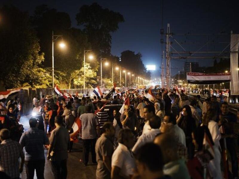 Hundreds of Egyptian protesters wave national flags and shout slogans against President Mohammed Morsi outside the presidential palace (AFP)