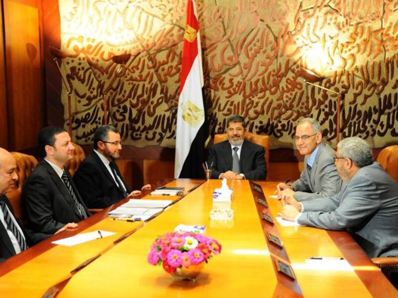  In this handout picture released by the Egyptian Presidency, Egyptian President Mohamed Morsi (C) meets with his prime minister Hisham Kandil (3rd L) and other ministers in Cairo on July 1, 2013. 