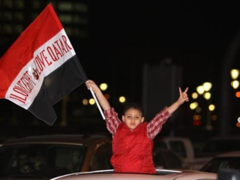 Egyptian boy bears the note of endearment: "love Egypt, love Qatar"  during celebrations by his community of Mubarak's downfall.