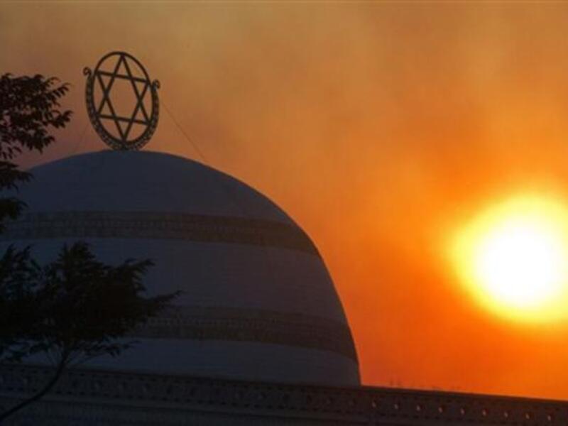 The sun rises amidst smoke of ongoing fire in Tirat Ha Carmel near the northern city of Haifa.