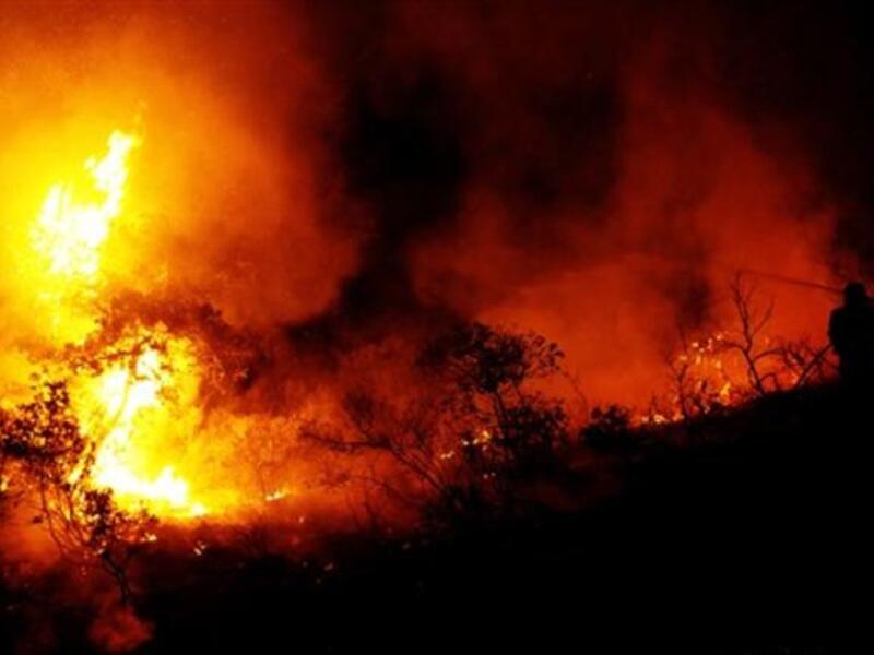Israeli firefighters work on the slope of a burning hill in Tirat Ha Carmel near the northern city of Haifa