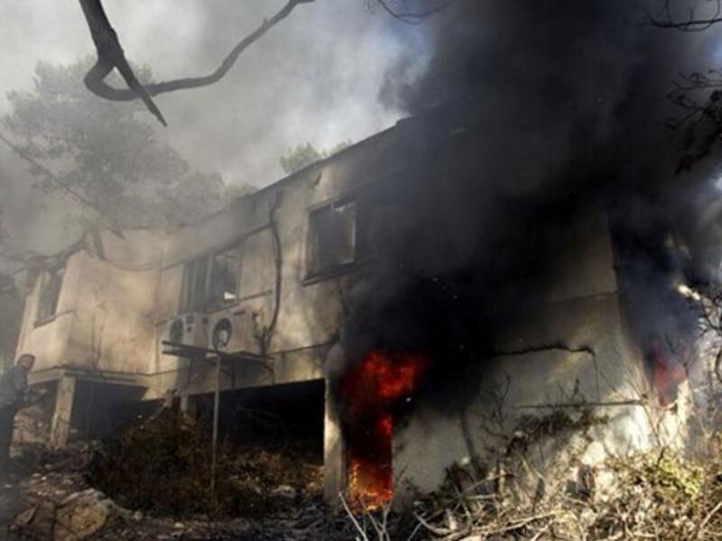 An Israeli firefighter prepares to douse a burning house in the Artists; village of Ein Hod near the northern city of Haifa.