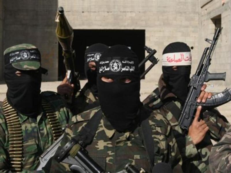 Armed Palestinians are seen following a press conference.