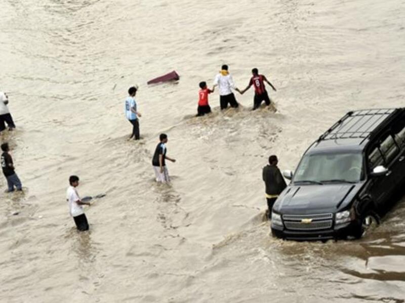Enjoying the disaster is easier than sadness, as Saudis are walking through the flooded street.