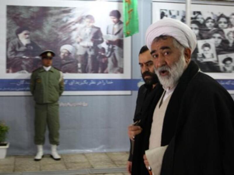 Clerics walk past posters showing the late founder of the Islamic Revolution Ayatollah Ruhollah Khomeini, outside Khomeini's mausoleum as they arrive to attend the ceremony.