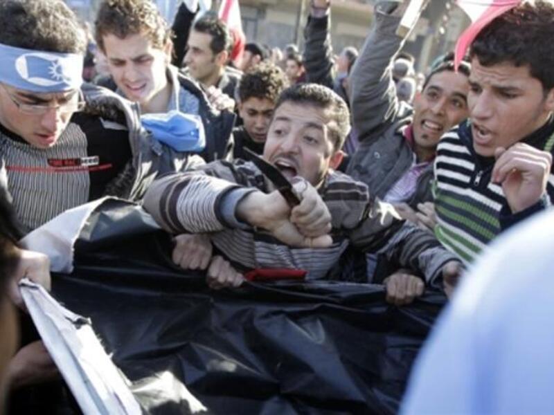 Supporters of the Future Movement rip a poster of Lebanese MP Najib Mikati during a demonstration in support of the caretaker prime minister Saad Hariri.
