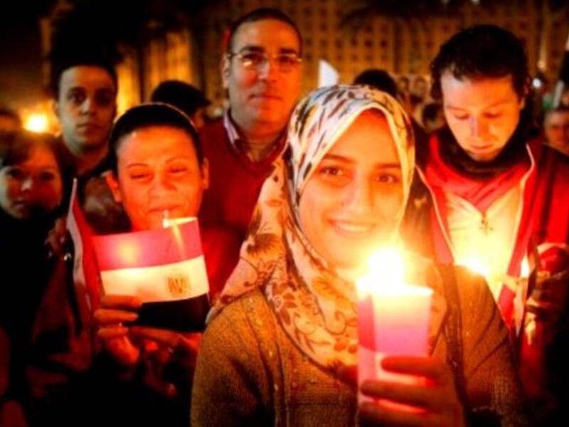 Thousands of Egyptian Muslims and Coptic Christians attend a celebration on New Year's eve in Tahrir Square in Cairo.