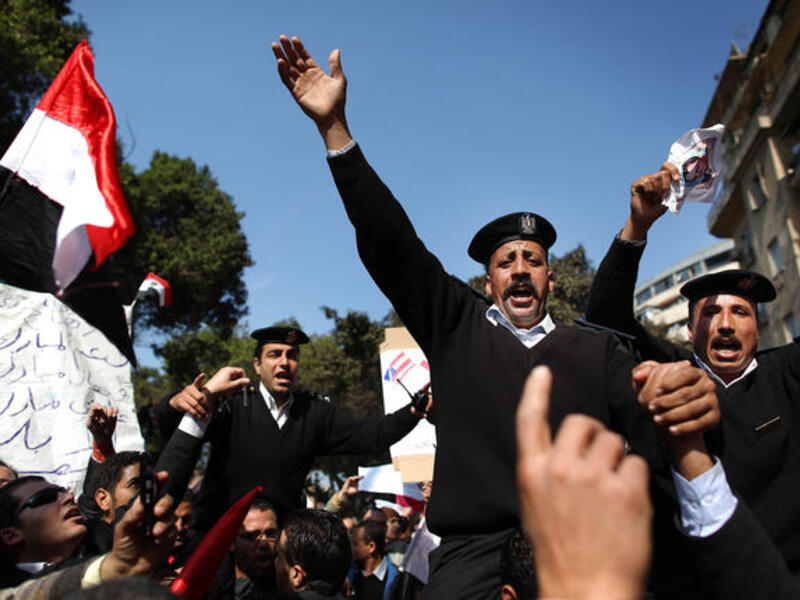 Policemen are carried during a demonstration in support of President Hosni Mubarak.
