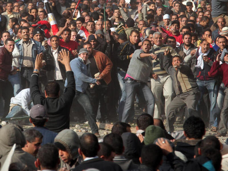 Anti-government protestors (front) clash with supporters of President Mubarak.