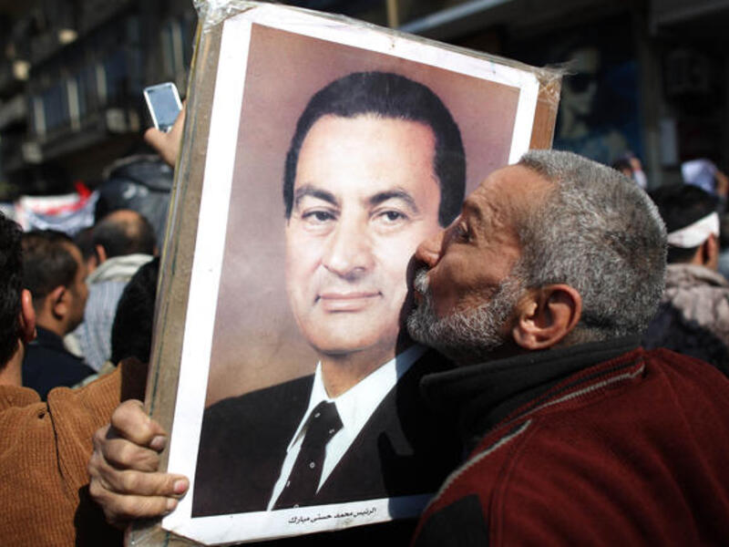 A man kisses a photograph of President Hosni Mubarak during a pro-government demonstration.