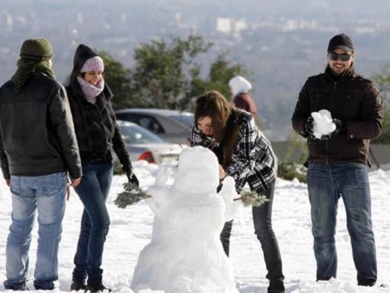 Syrians play with snow in Damascus as the Syrian capital was lashed by a snowstorm which disrupted traffic but brought some relief from a drought which has gripped the country for the past four years.