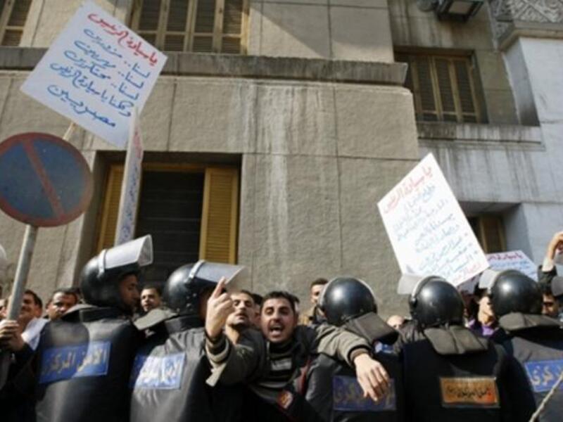 Arabic writing on placard (L) reads: "Mr. President, we are not riggers nor smugglers nor monopolists and we are all Egyptians".