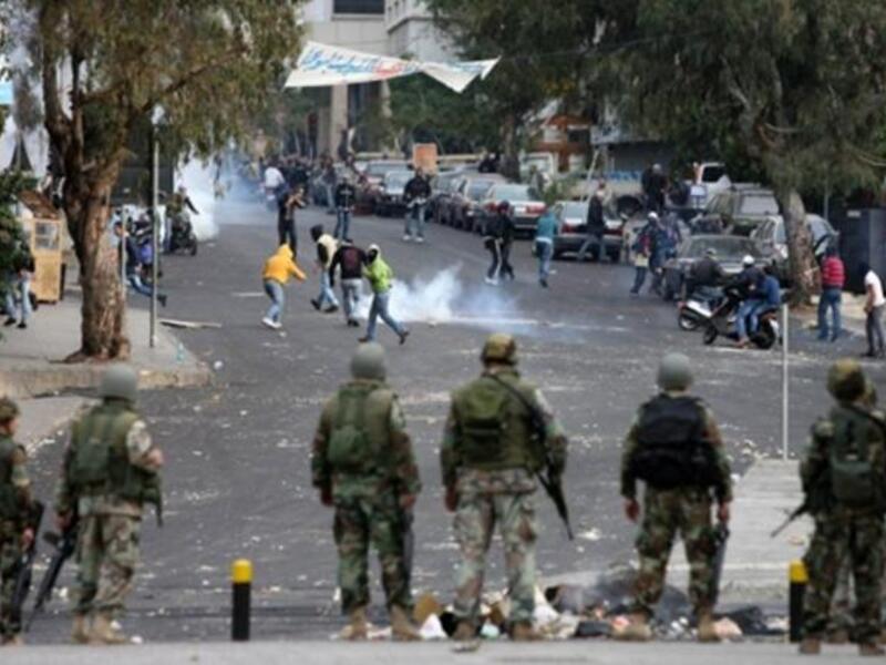 LEBANON: Lebanese soldiers look on as supporters of former Lebanese prime minister Saad Hariri Future Movement flee from tear gas, January 25, 2011.