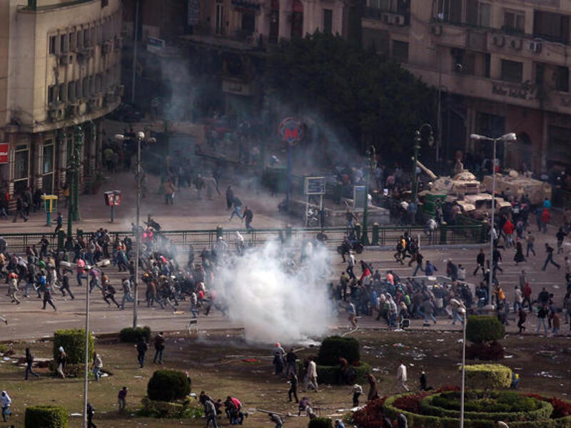 Protesters flee a volley tear gas in Tarhir Square.