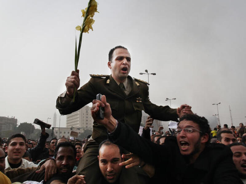 Protesters carry an army captain on their shoulders after he tore up a poster of Egyptian President Hosni Mubarak.