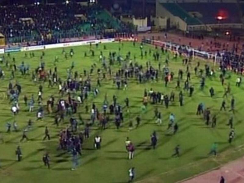 Fans rushing off the football pitch. 'Ultra' trouble-maker, fanatic football fans who had also been involved in the revolution - happy to make sport a politically-charged arena. These Ultras may have been finishing off business from Tahrir, specifically at the 'camel' battle. Al Masry fans held provocative banners aimed at the rival team Al Ahly.