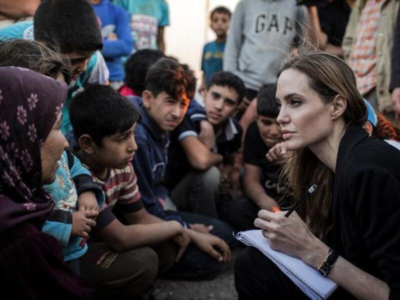 US actress Angelina Jolie listening to Syrian refugees in a Jordanian military camp based the the Jordan-Syria border (UNHCR / AFP)