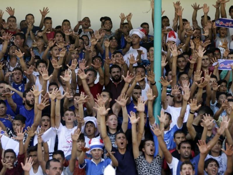 Fans of Shabab Rafah football club celebrate their team's victory against Hebron's Ahly al-Khalil football club in the first leg of the Palestine Cup final at the Yarmouk Stadium in Gaza City on August 1, 2017.
MAHMUD HAMS / AFP