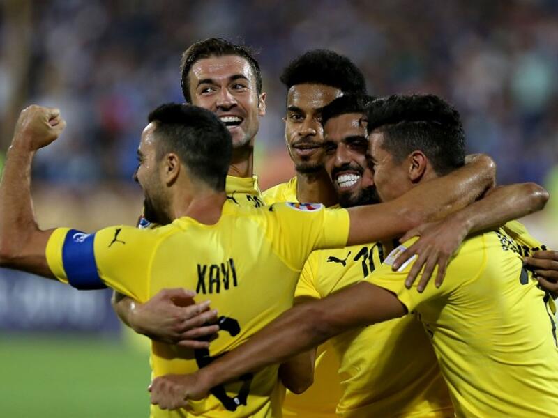 Al-Sadd's forward Baghdad Bounedjah (1st-R) celebrates after scoring a goal with his teammates, Spanish midfielders Xavi Hernandez (1st-L) and Gabi (2nd-L) during the AFC Champions League football match Al-Sadd (Qatar) vs Esteghlal FC (Iran) at the Azadi stadium in Tehran on August 27, 2018.
ATTA KENARE / AFP
