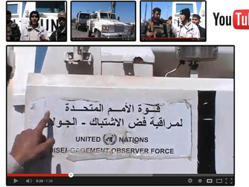  An image grab taken from a video uploaded on YouTube on Wednesday, allegedly shows armed fighters standing in front of a United Nations Disengagement Force (UNDOF) vehicle in the Golan Heights between Syria and Israel. (Image courtesy of AFP / YouTube)